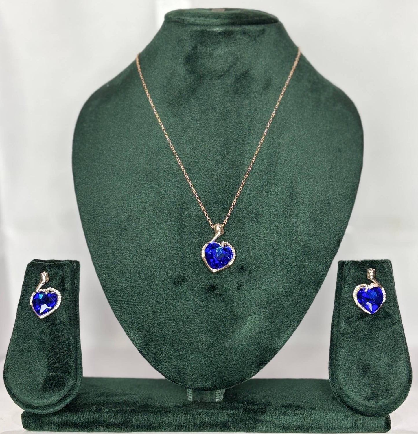 Jewelry set with heart-shaped blue pendant and matching earrings .