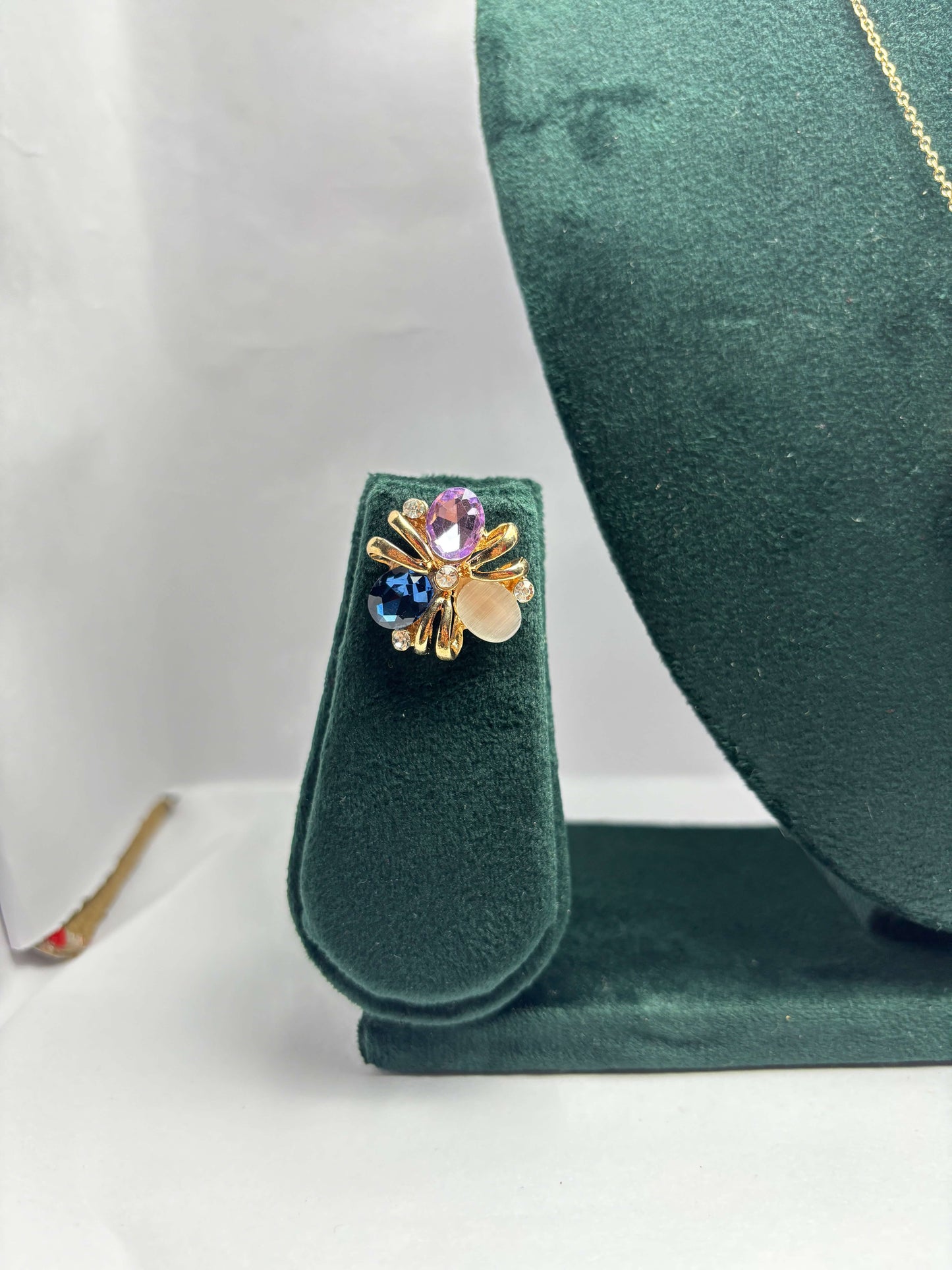 Gold earring with multicolored gemstones.