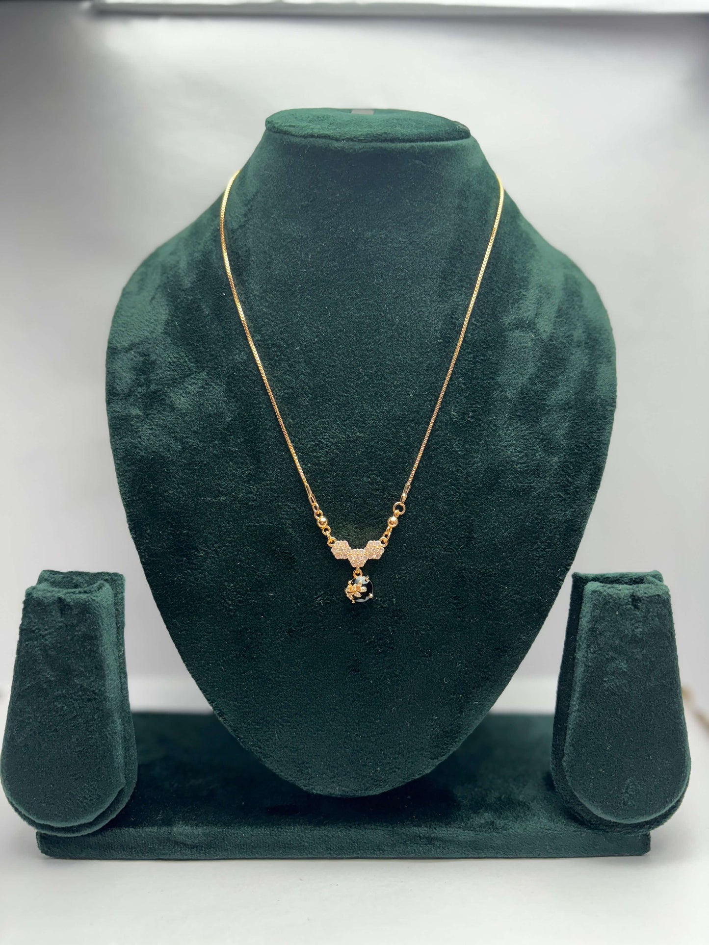 Gold necklace with a black stone pendant
