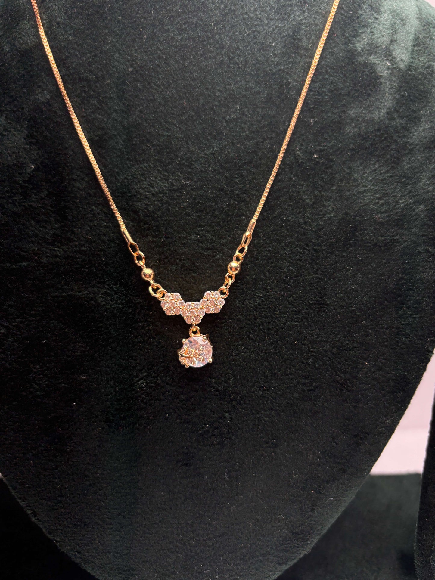 Gold necklace with a pink pendant