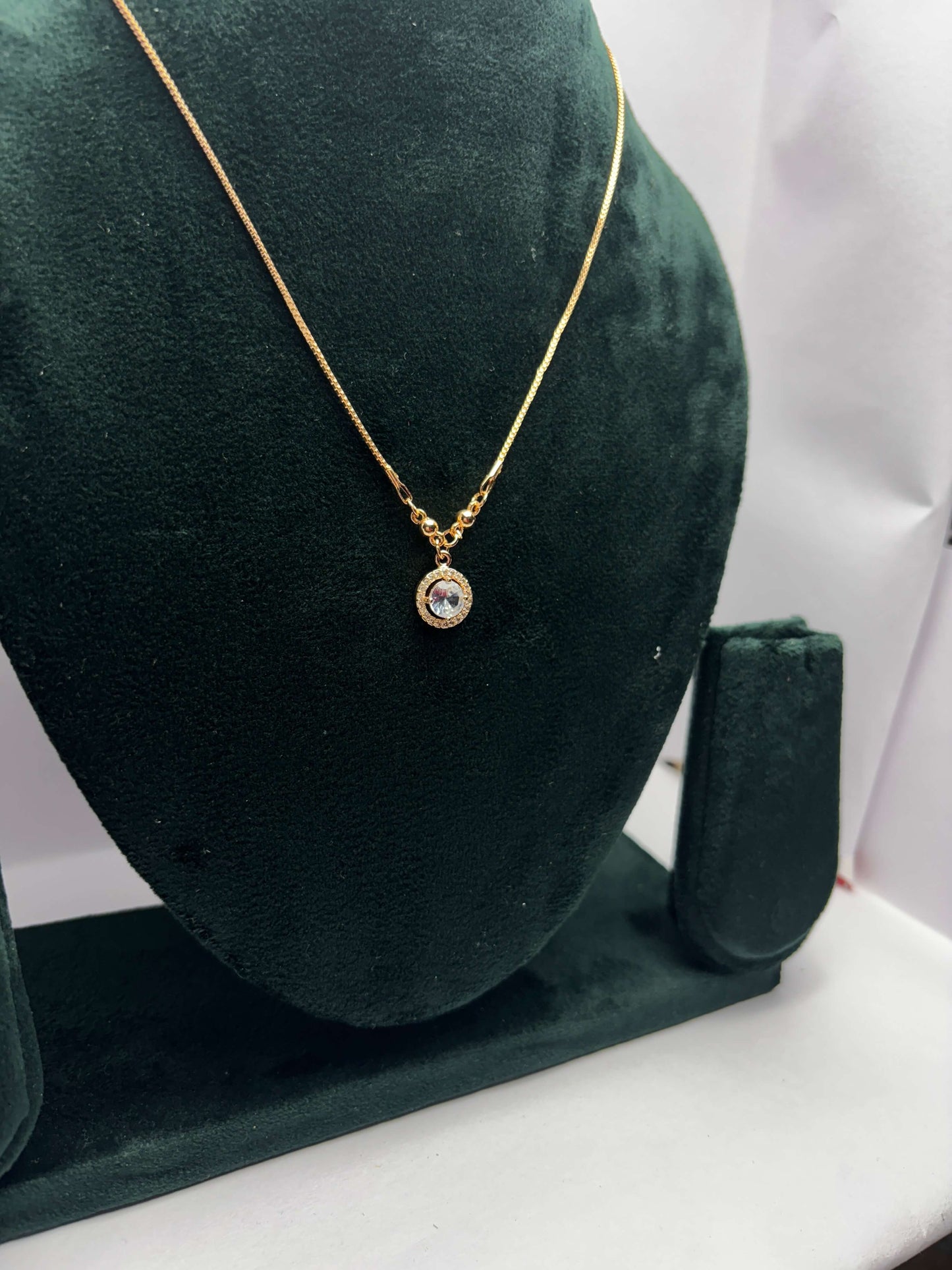 Gold necklace with a pendant.