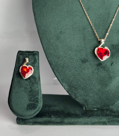 Heart-shaped red gemstone pendant on a gold chain displayed 