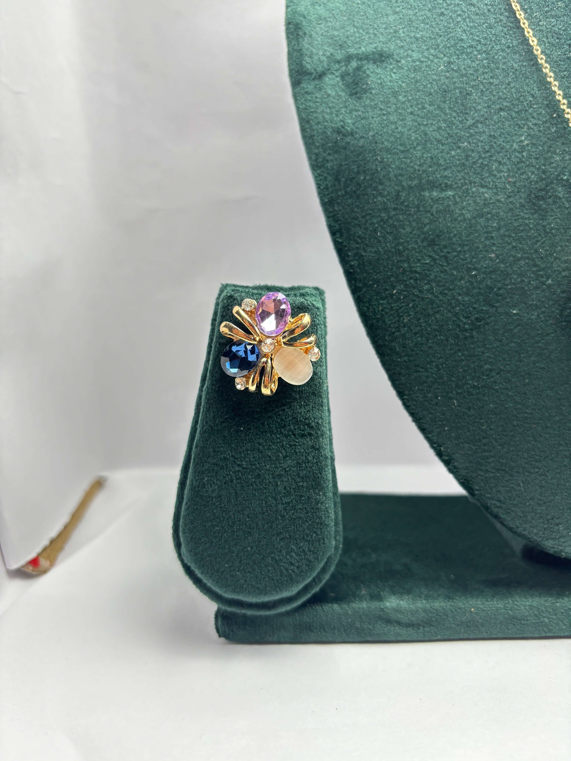 Gold earring with multicolored gemstones.