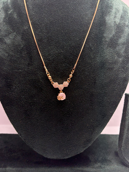 Gold necklace with a pendant on a black velvet surface