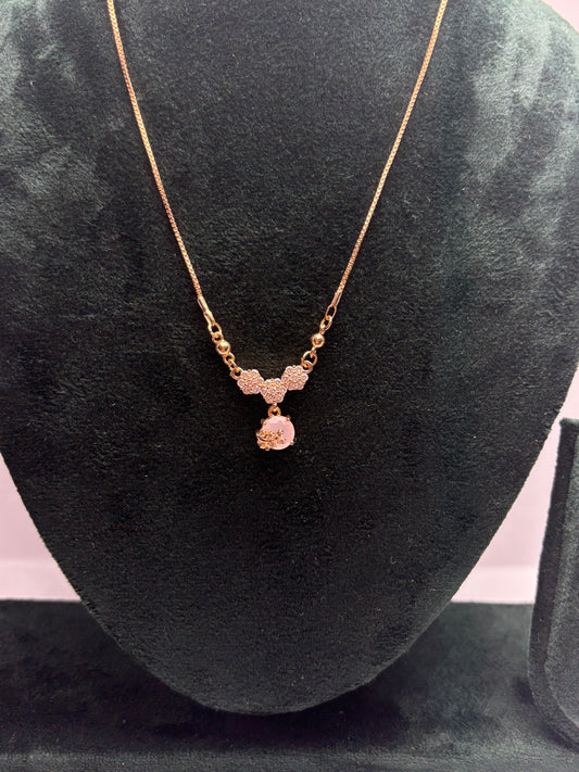 Gold necklace with a pendant on a black velvet surface