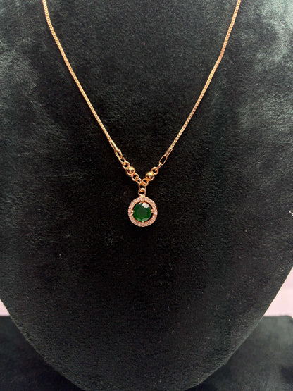 Gold necklace with a green gemstone pendant.