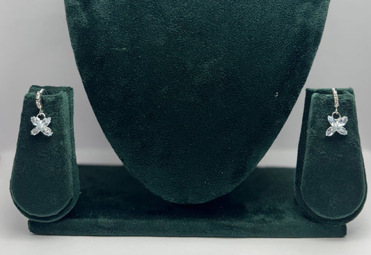 Pair of butterfly-shaped earrings on a green velvet stand.