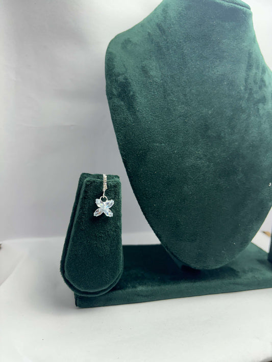 Starfish-shaped pendant on a green velvet stand against a white background