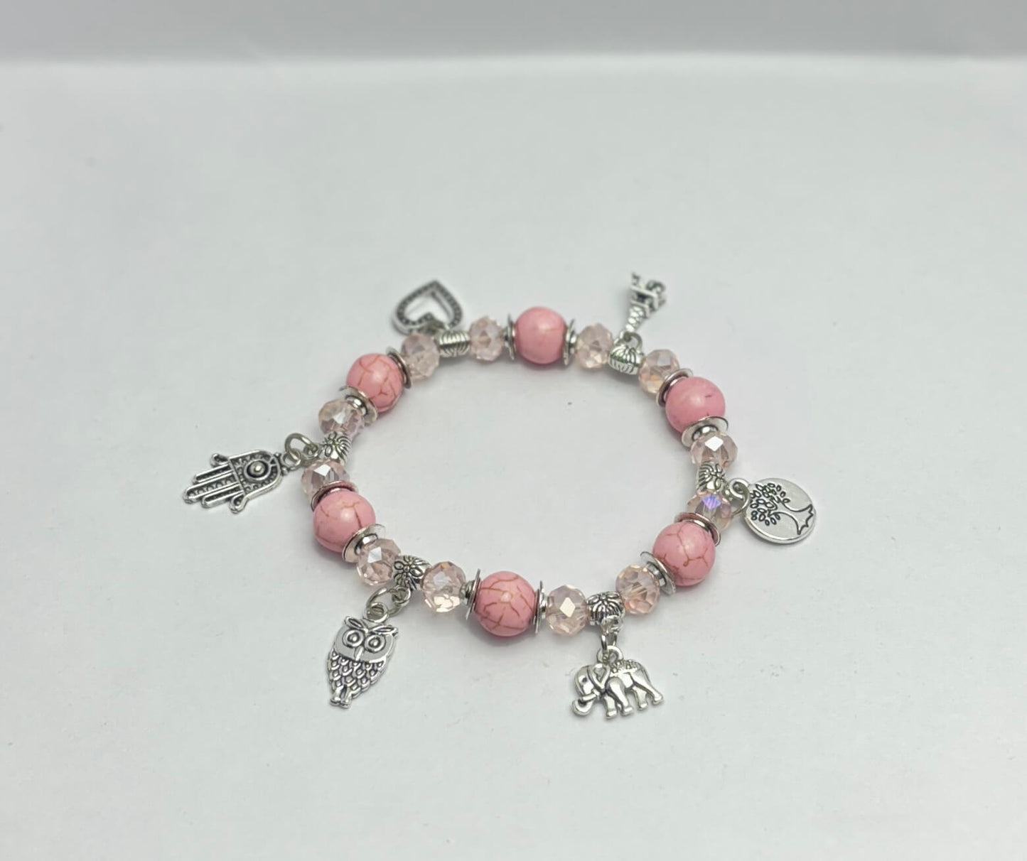 Bracelet with pink beads and charms on a white background