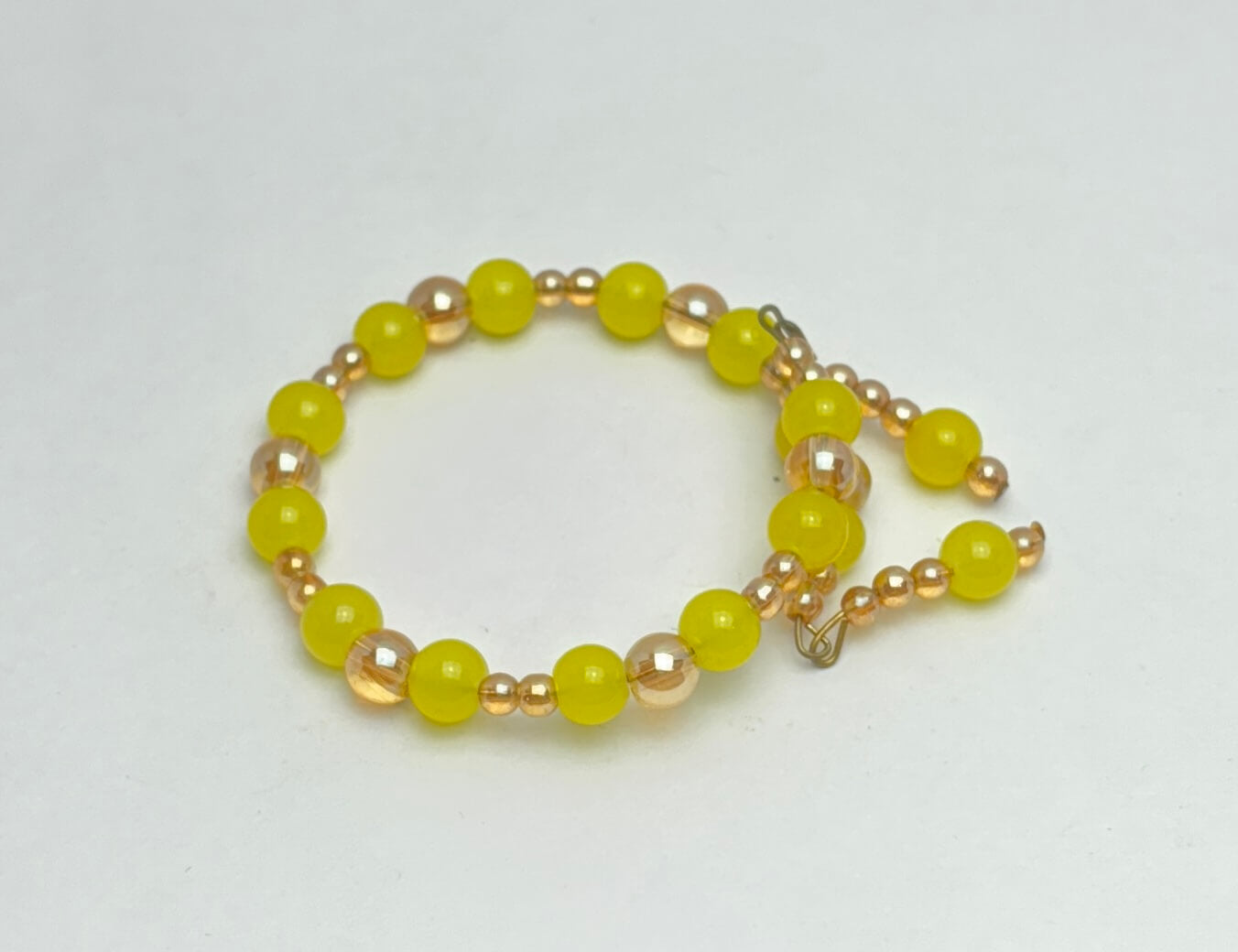 Beaded bracelet with yellow and gold beads on a white background