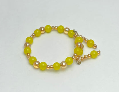 Beaded bracelet with yellow and gold beads on a white background